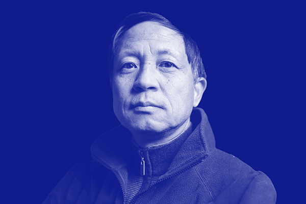 Older asain man wearing a zip-up jacket looking off into the distance